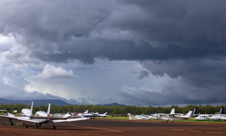 Small planes with storm clouds overhead