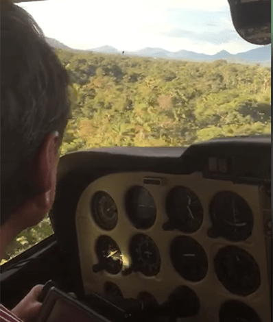 A screenshot from a video showing a pilot land in a jungle.