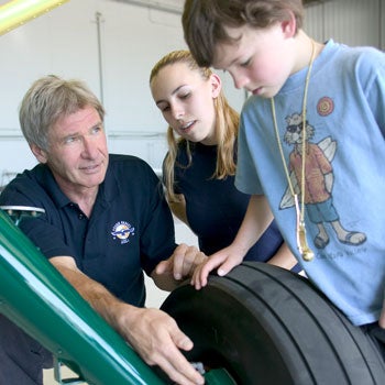 Actor and former chairman of the Young Eagles program Harrison Ford with two members