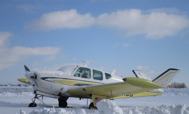 A Beechcraft Bonanza sits in the snow.