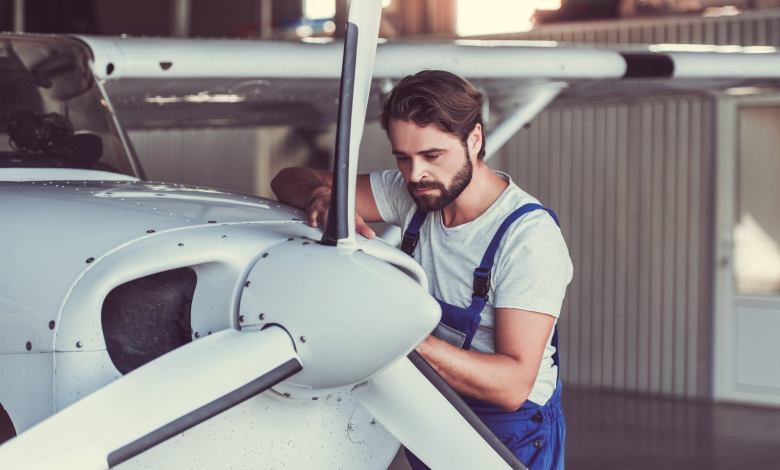 Aircraft mechanic standing next to airplane engine