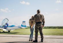 Father and daughter at airfield looking at plane