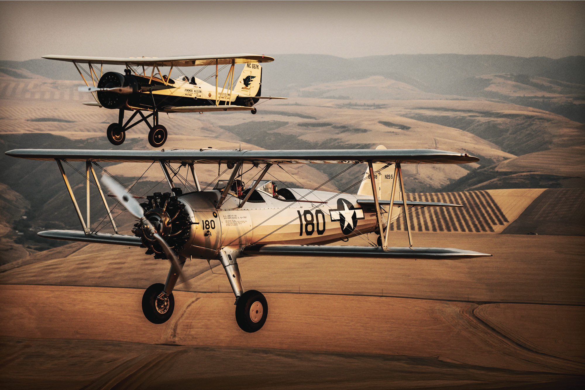 Hangar 180’s Boeing PT-13 Stearman and Stearman 4E Junior Speedmail fly in formation over western Idaho. [Credit: Cayla McLeod]