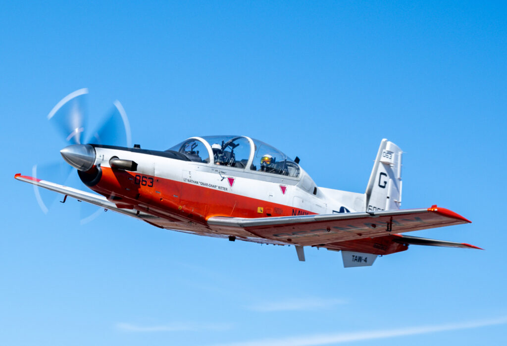 A Beechcraft T-6 Texan II trainer flies high over Horseshoe Bay, Texas, after departure.