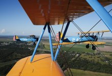 A formation of Boeing PT-17 Stearmans flies high over Louise, Texas, at the annual Under the Wire Fly-In. [Credit: Cayla McLeod]