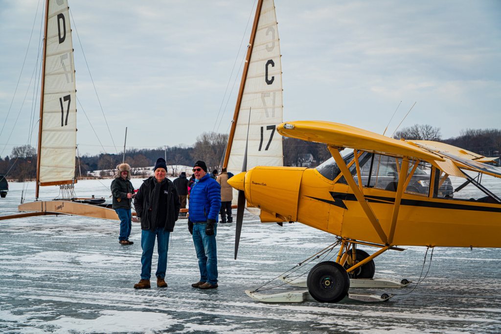 Many pilots don’t seem to mind the cold after landing on a frozen lake in Wisconsin. [Credit: Jim Stevenson]