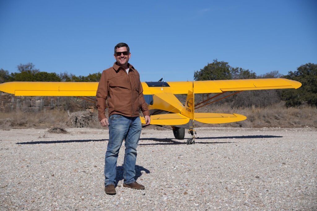 Tres Clinton, owner and founder of C3 Air, stands on a gravel bar after a successful flight in his Carbon Cub EX.